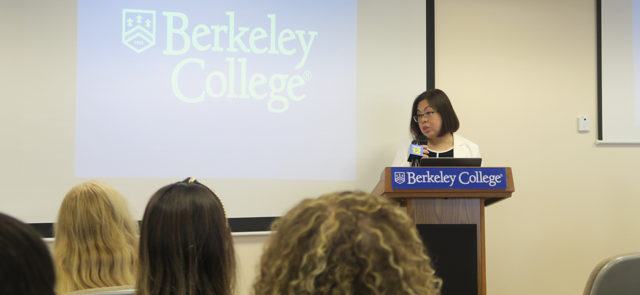 Photo of Mary Jane Genuino in front of a podium speaking
