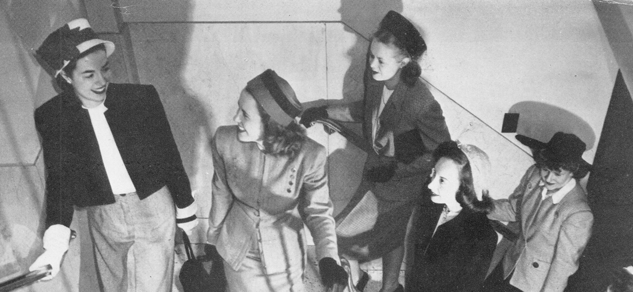 Black and white of 5 women walking up the stairs