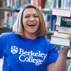 Headshot of Tamara Kostadinova holding a stack of books close to her chest