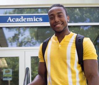 Photo of Berkeley College student in front of Academics building at the Woodland Park campus. mobile image