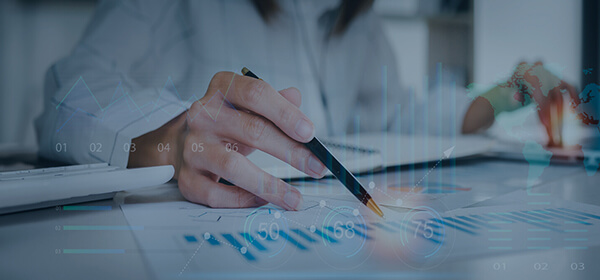 A person writing on a laptop screen with a pen