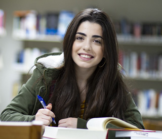 Honors Program student at desk with laptop and books mobile image