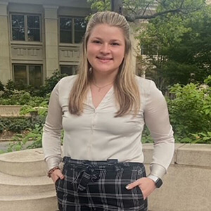 Kallie McGrath in a white shirt and plaid pants posing in a casual look