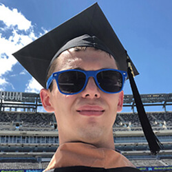 Headshot of Sean Smith wearing a graduation cap and sunglasses