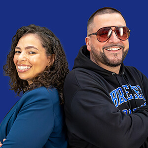 Two individuals standing side by side against a solid blue background