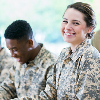 A woman in a military uniform poses proudly, representing her commitment and professionalism in the armed forces