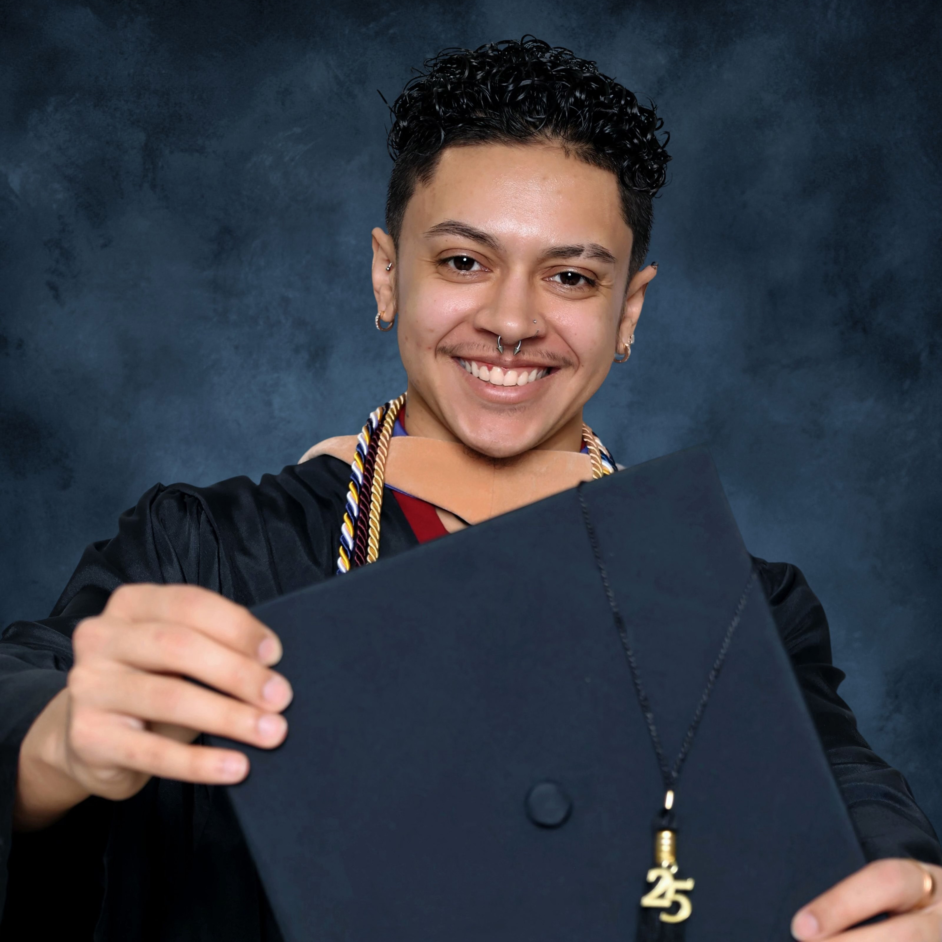 Berkeley graduate Jianni enzo dejesus holds his graduate cap out in front of him