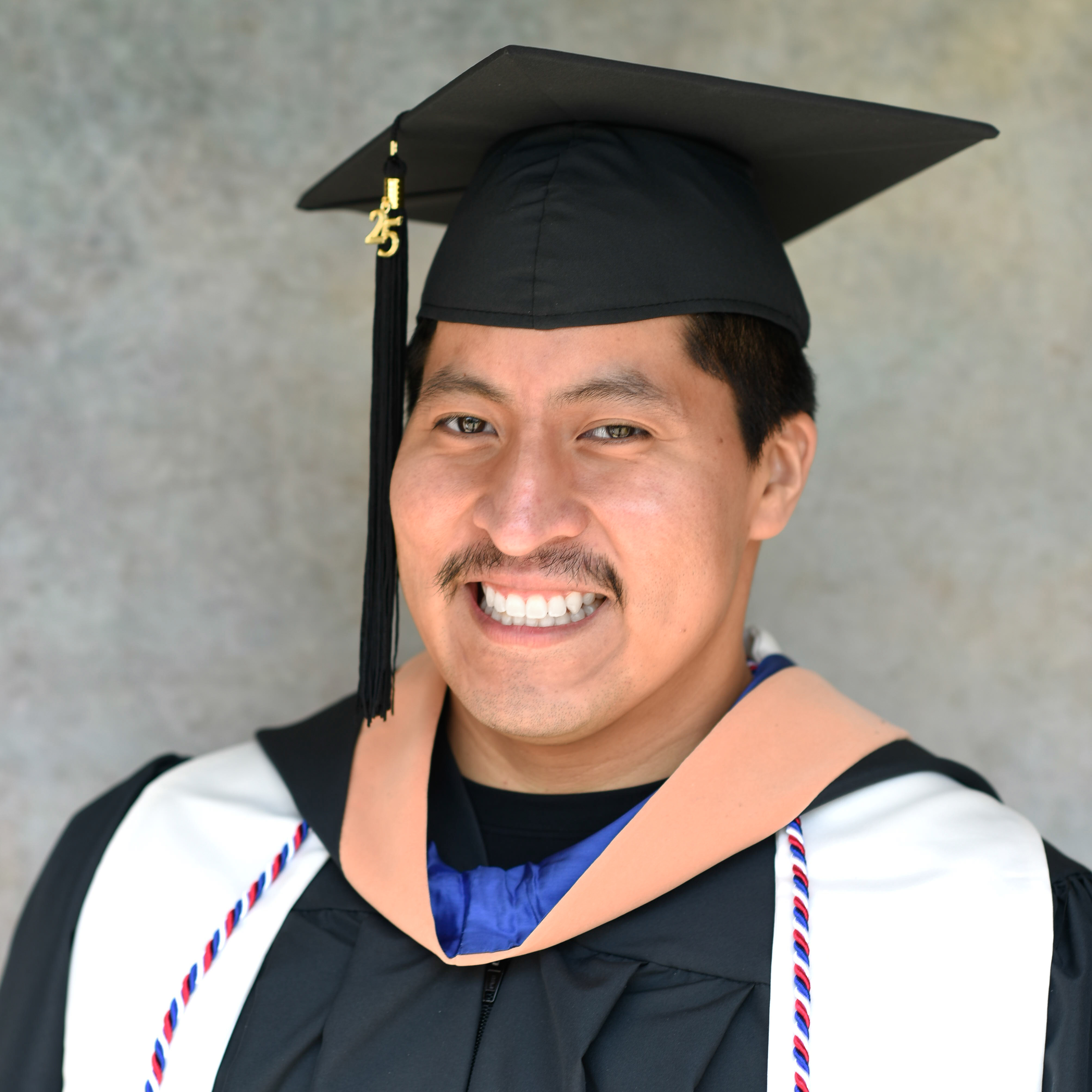 Berkeley nursing graduate Steven Alonzo wears his cap and gown with regalia