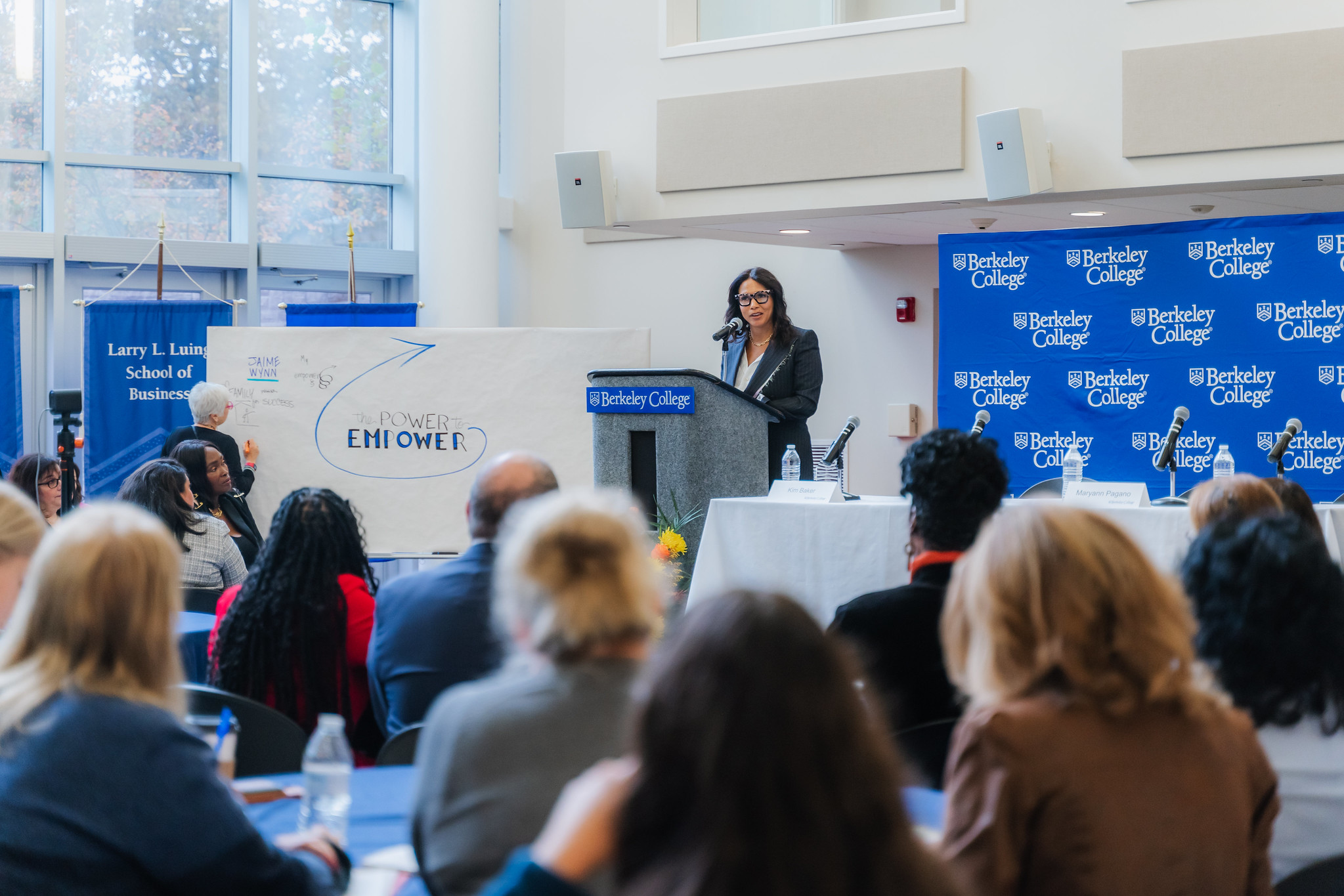 Berkeley A woman speaks at a podium to a full room of attendees