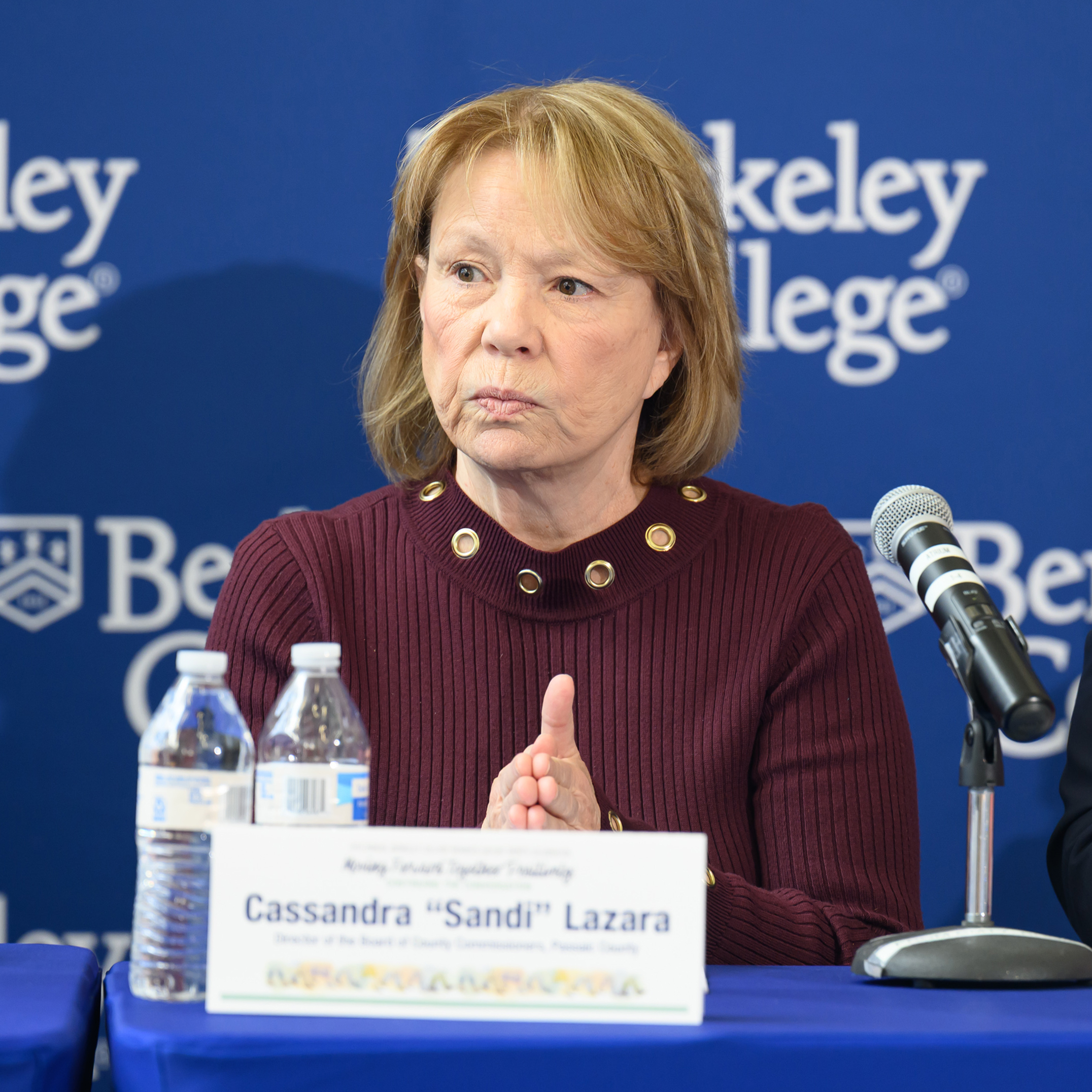 A woman sits in front of a tabletent card