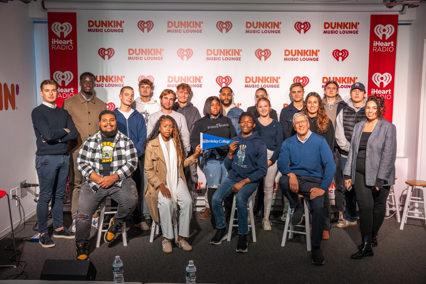 Students and staff smile and pose for a photo in a music lounge
