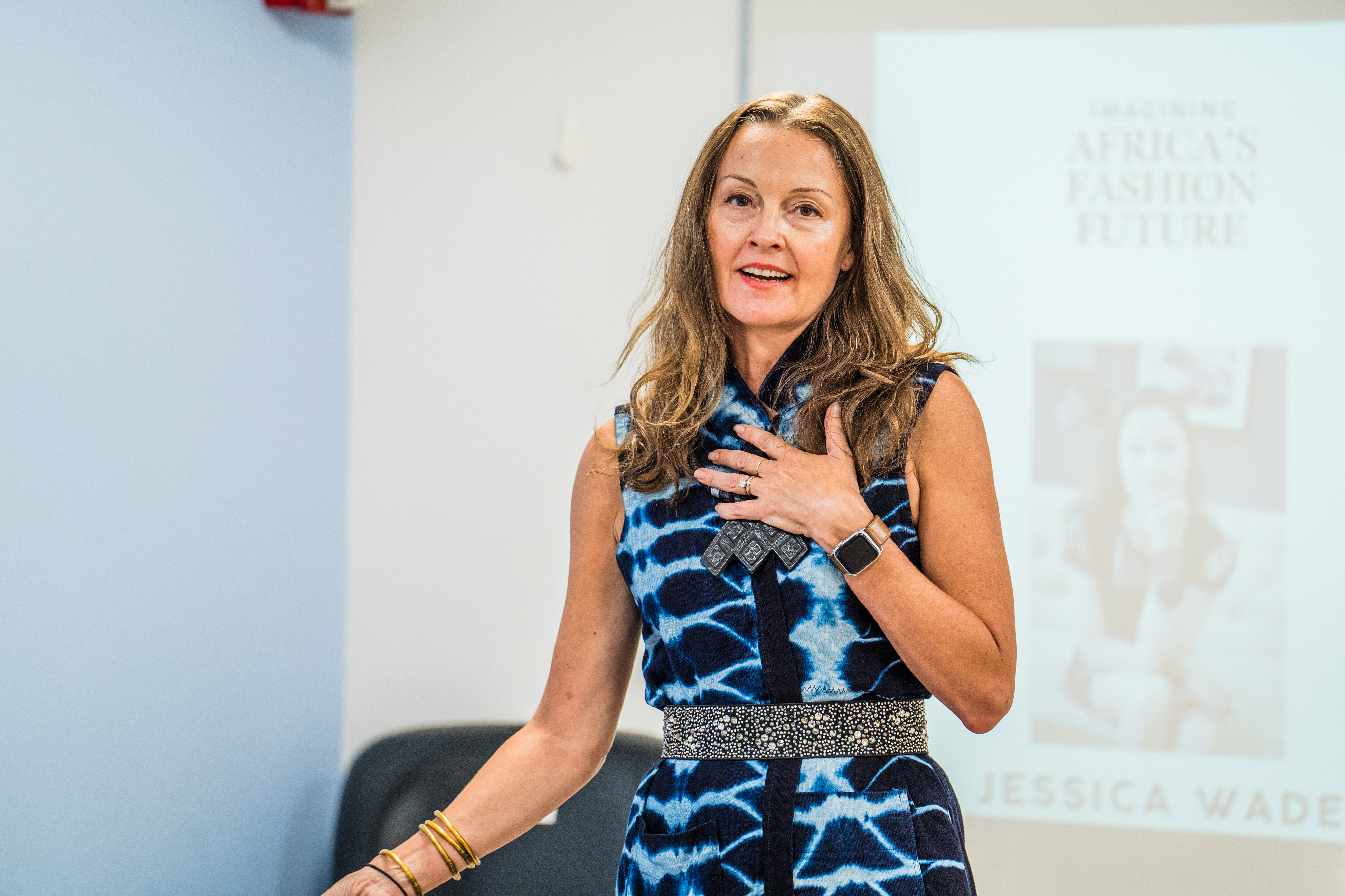A woman in a blue outfit smiles