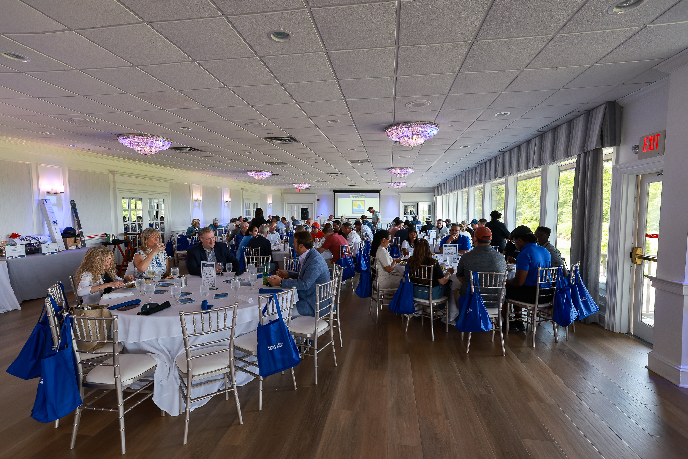 A crowd sitting and dining at a country club.